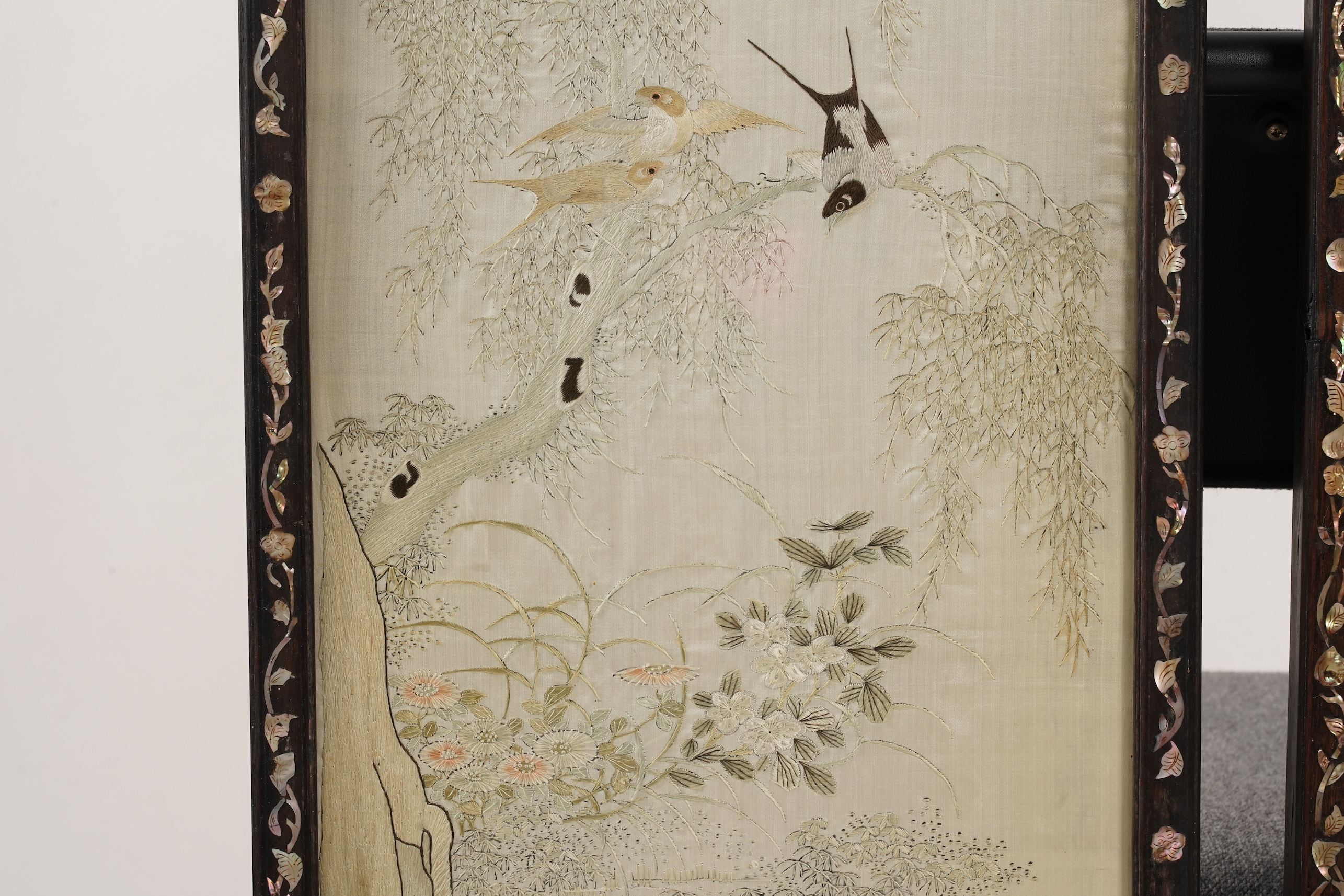 A pair of Chinese embroidered silk ‘bird’ panels, in mother-of-pearl inlaid hongmu frames, late 19th/early 20th century